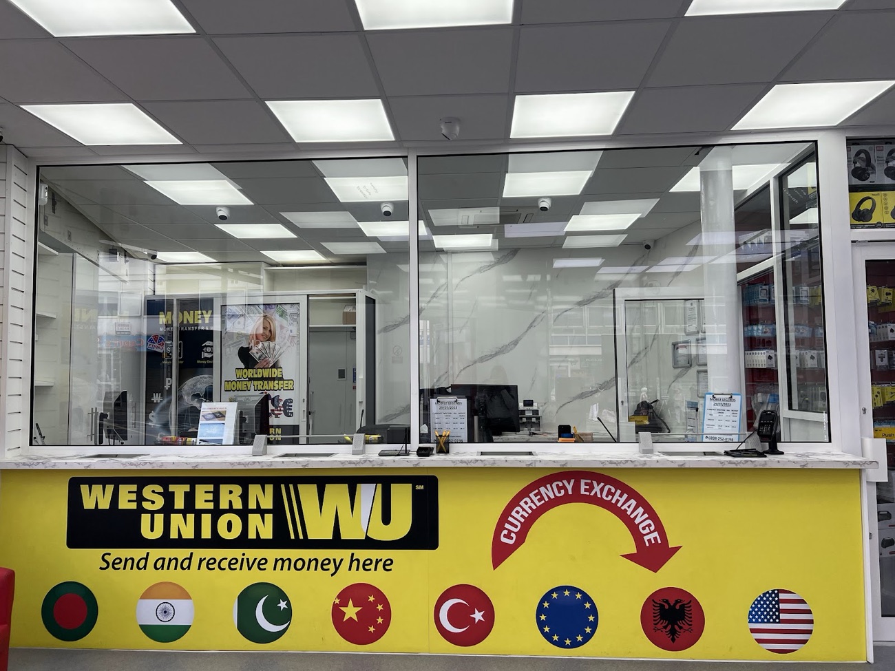 The yellow Western Union and currency exchange counter at Mobile Legends showing world currency flags.